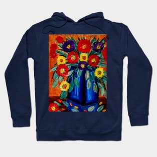 A lovely boutique of abstract bright abd vibrant l flowers in a tall glass  blue vase . Hoodie